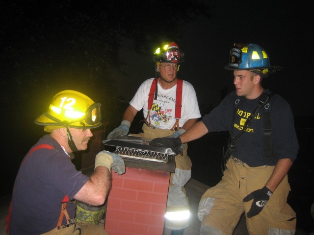 Lt. Robbie Ruch gives Firefighters Joel Margolies and Tom White some chimney fire pointers